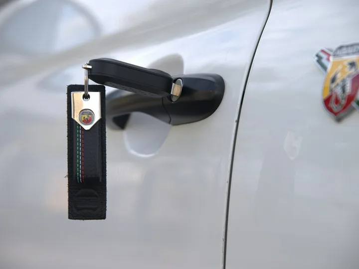 Chaveiro automotivo em Varginha: chave de carro pendurada na maçaneta da porta do veículo